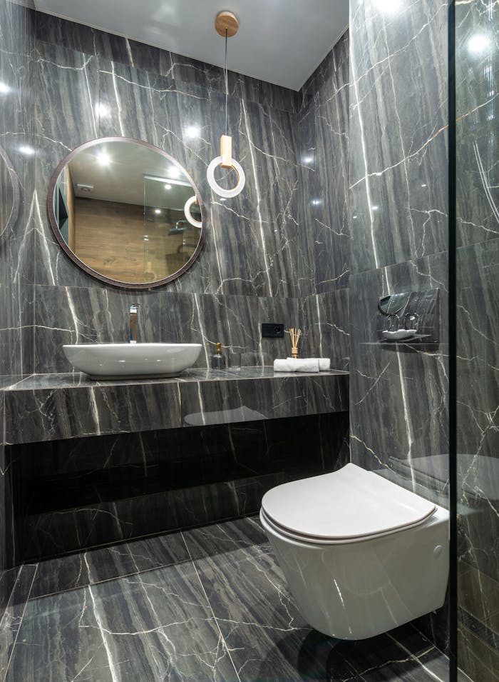 Luxurious bathroom interior featuring sleek marble walls, floating sink, and a contemporary toilet design.